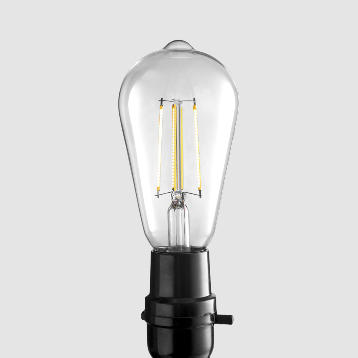Edison-style LED filament bulb hero shot on neutral gray background, commercial product photography by PROSPEKT Product Works